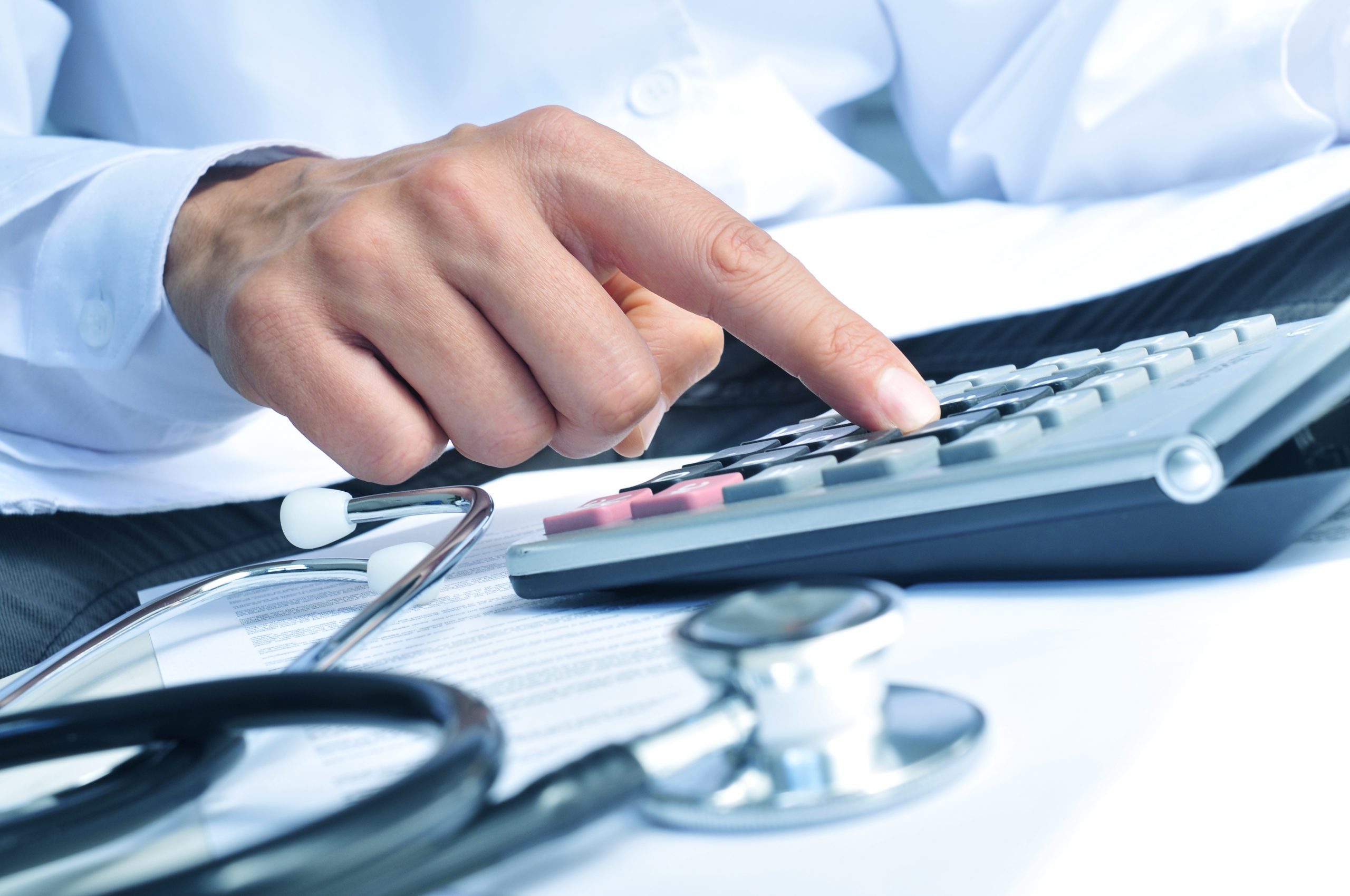 healthcare professional calculating on an electronic calculator