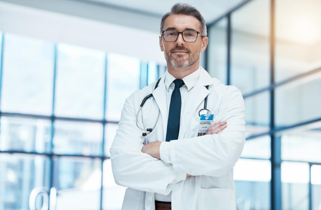 Senior doctor with stethoscope and crossed arms in clinic