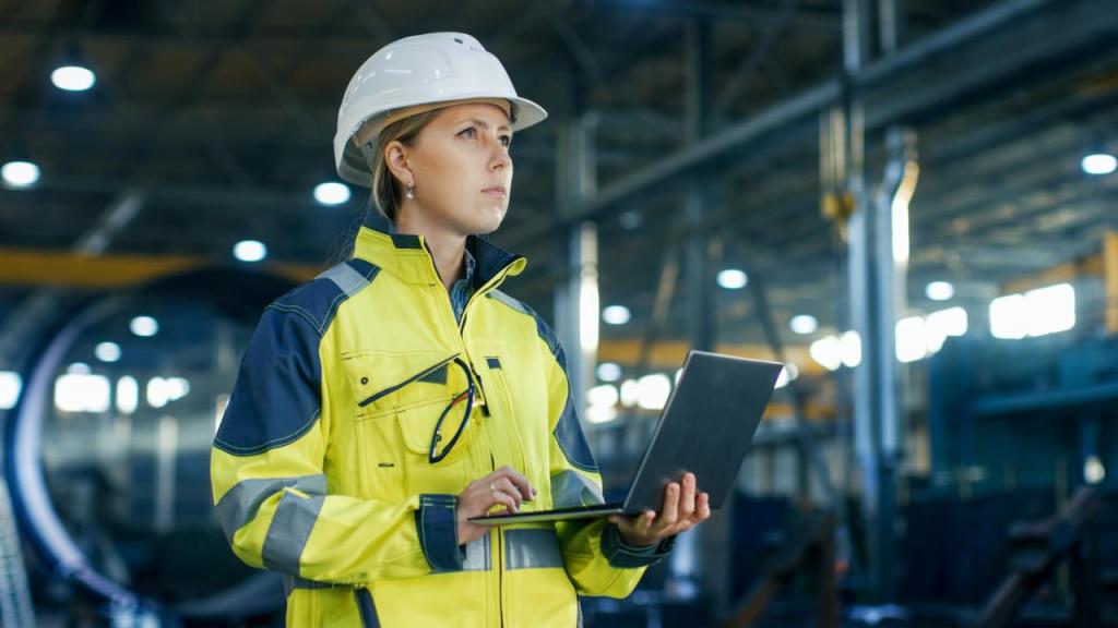 Female engineer in hard hat using laptop at worksite